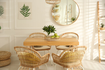 Fototapeta premium Stylish wooden dining table and chairs in room. Interior design
