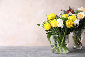 Beautiful bouquets with fresh flowers on grey table, space for text