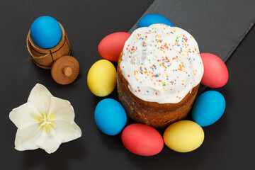 Easter cake and colored Easter eggs on black background.