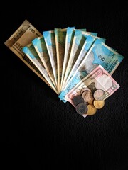 Piles of currency Indian Rupees in notes of 500s and 50s and coins and change, india