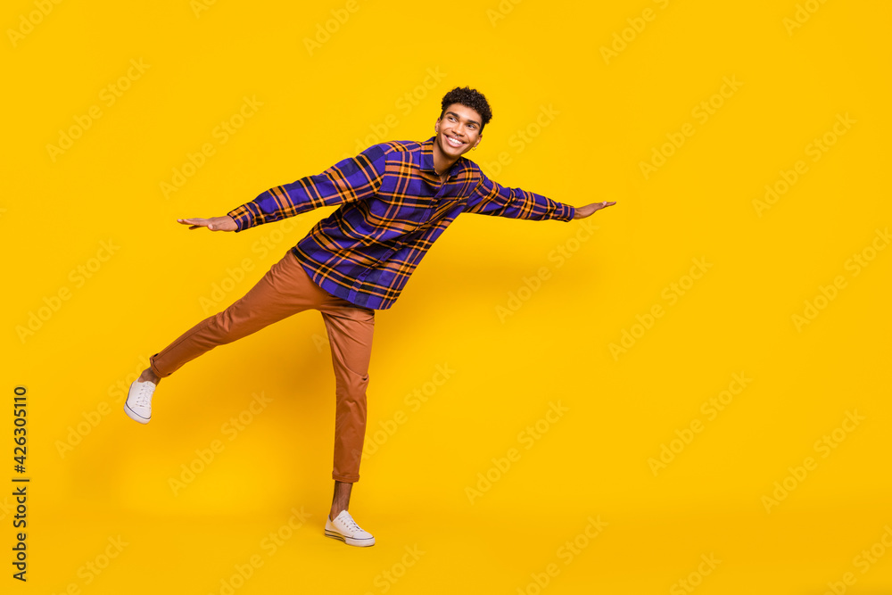 Sticker Full body profile photo of positive dark skin guy look empty space arms flying isolated on yellow color background