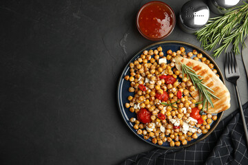 Delicious fresh chickpea salad served on black table, flat lay. Space for text