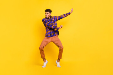 Fototapeta na wymiar Full size portrait of cheerful dark skin person enjoy dancing have good mood isolated on yellow color background