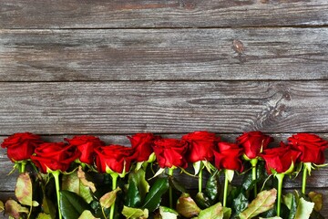 Obraz na płótnie Canvas Bouquet of red roses on a wooden background. A greeting card. Space for text, top view. Mothers day. Valentines day. Womans day. Happy birhday.