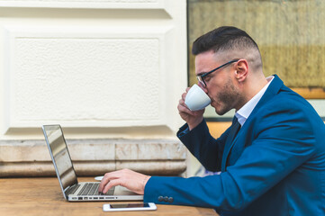 Fototapeta premium Businessman Using Laptop While Drinking Coffee in a Cafe.