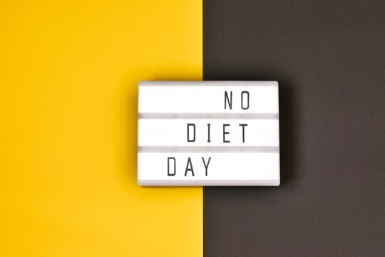 Lightbox with text NO DIET DAY  on a yellow-gray background. Internatinal no diet day.