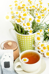 cup of herbal chamomile tea with fresh daisy flowers  background, treatment and prevention of immune concept, medicine - folk, alternative, complementary, traditional medicine