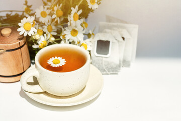 cup of herbal chamomile tea with fresh daisy flowers  background, treatment and prevention of immune concept, medicine - folk, alternative, complementary, traditional medicine