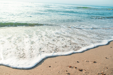 Fototapeta na wymiar Close Up Wave Sand Beach Sea Foam. Closeup of sea wave with foam on beach sand. Vacation Summer background 