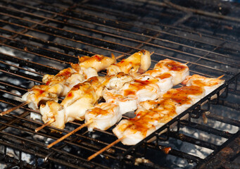 The barbecuing squid on skewers with spicy sauce