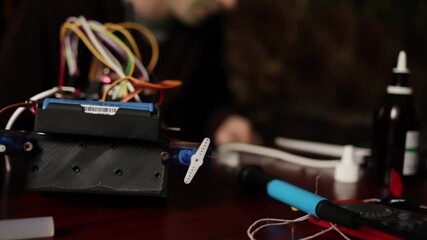 DIY, the machine on electronic control. Home experiments, robotics, smart engineer. Toy for the child. A man stitches an electronic device using a computer code of the program. laptop.