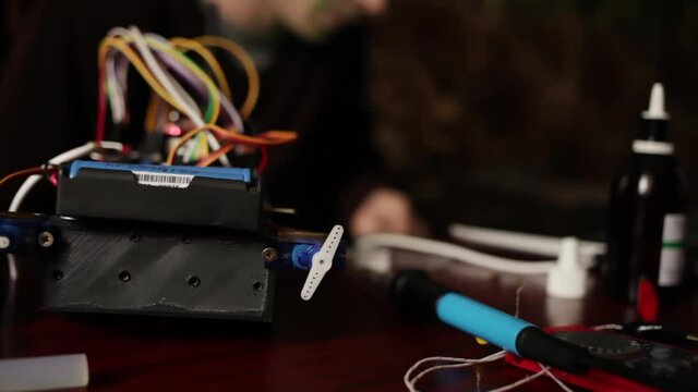 DIY, the machine on electronic control. Home experiments, robotics, smart engineer. Toy for the child. A man stitches an electronic device using a computer code of the program. laptop.