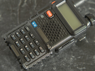 Compact but powerful walkie-talkie in black with a display on a dark background