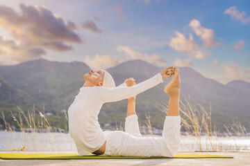 Kundalini yoga woman in white clothes and turban practices yoga kundalini on the background of the...