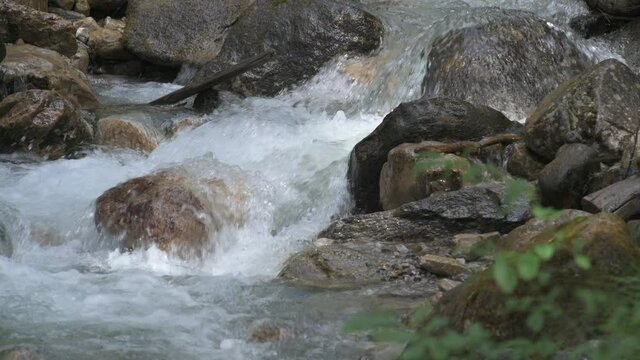 Detailaufnahme einer Stromschnelle eines Bergbachs mit Gletscherwasser. Lange Belichtungszeit.