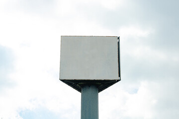 Blank triangular billboard on the cloudy sky background
