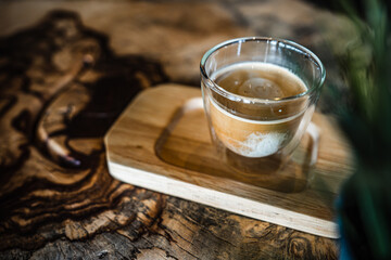 Hot coffee with milk on a wooden tray Set on a wooden table, with a beautiful pattern.