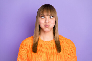 Photo of foolish lady crossed eyes puffed blow cheeks wear orange pullover isolated violet color background