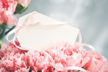 Blank tag in a bouquet of pink carnations.