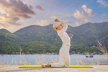 Kundalini yoga woman in white clothes and turban practices yoga kundalini on the background of the...