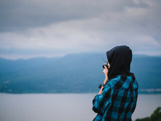 Young woman with camera outdoors portrait.