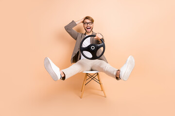 Full size photo of happy excited crazy smiling man in glasses riding car speed extreme isolated on...