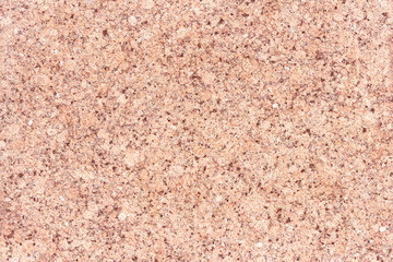 The texture of a hewn granite slab with a colorful pattern. Facing material for walls made of natural stone.