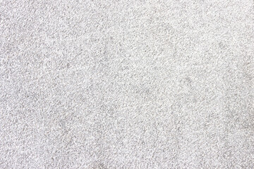 The surface of a light gray rough granite wall. Processed natural stone.