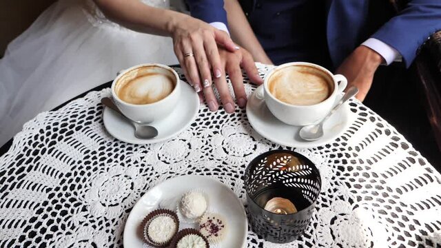 newlyweds drink cappuccino in a cafe