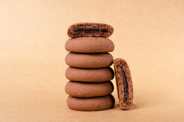 Fototapeta na wymiar Broken cookie with chocolate and stack of whole cookies on the rustic brown surface