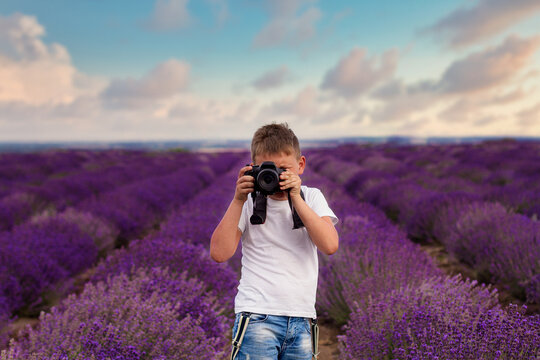 A teenager takes pictures of a lavender field. Teenager in a lavender field. Selective focus.