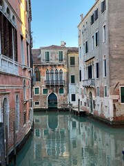 Small boat on a small canal street in Venice of beautiful colorful houses, Italy