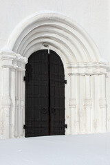Fototapeta premium Black cast iron gate door in white romanic portal