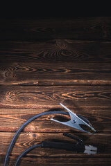 Welding wires on a wooden background. Place for the text. Studio photo in hard light.