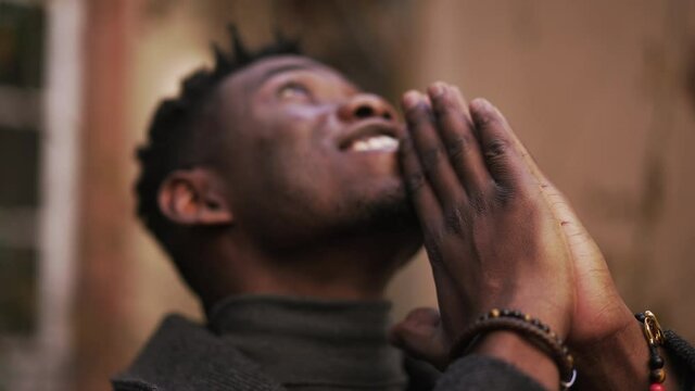 Spiritual black African praying looking up at sky seeking God
