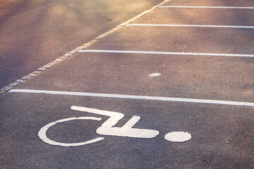 Empty parking lot, white lines on the asphalt, sunny day. Handicapped parking space at a parking...