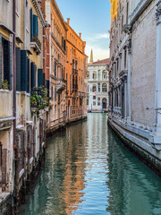 Fototapeta na wymiar Small canal in Venice, Italy, with balcony, and, blue sky reflexion on water, no boat, no people