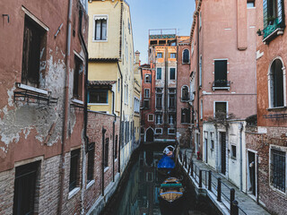 Fototapeta na wymiar Many Small boats on a small canal street in Venice with beautiful colorful houses, Italy