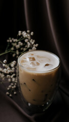 cup of coffee with ice and gypsophila on brown elegant atlas background