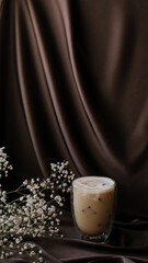 gypsophila and coffee on brown atlas background