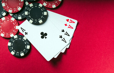 Poker game with a four of a kind or quads hand. Chips and cards on the red table