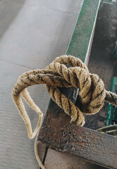 Thick rope knot at an industrial plant close-up.