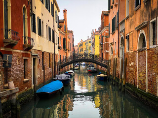 Fototapeta na wymiar Boats docking close to a Beautiful small bridge in Venice
