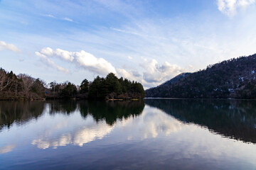 春の湯の湖の青い空と白い雲　湖面に映る空