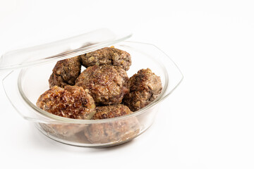 Ready homemade cutlets in a glass pan on a white background. The lid is ajar. White background, place for inscription