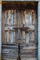 Old wooden door in Italy with iron sliding lock detail. Copy space