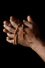 Hands of Indian Catholic man with wooden rosary