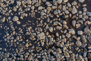 Rubble on the melted snow, floods. The texture of the stones. Background. Rubble for construction.