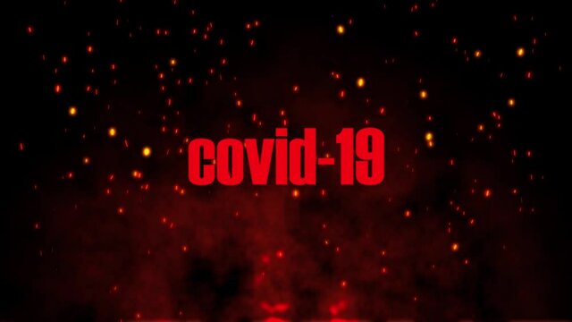 Inscription COVID-19 on Fire embers particles over black background