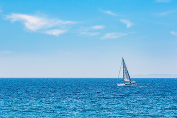 one sailboat at sea on a sunny day